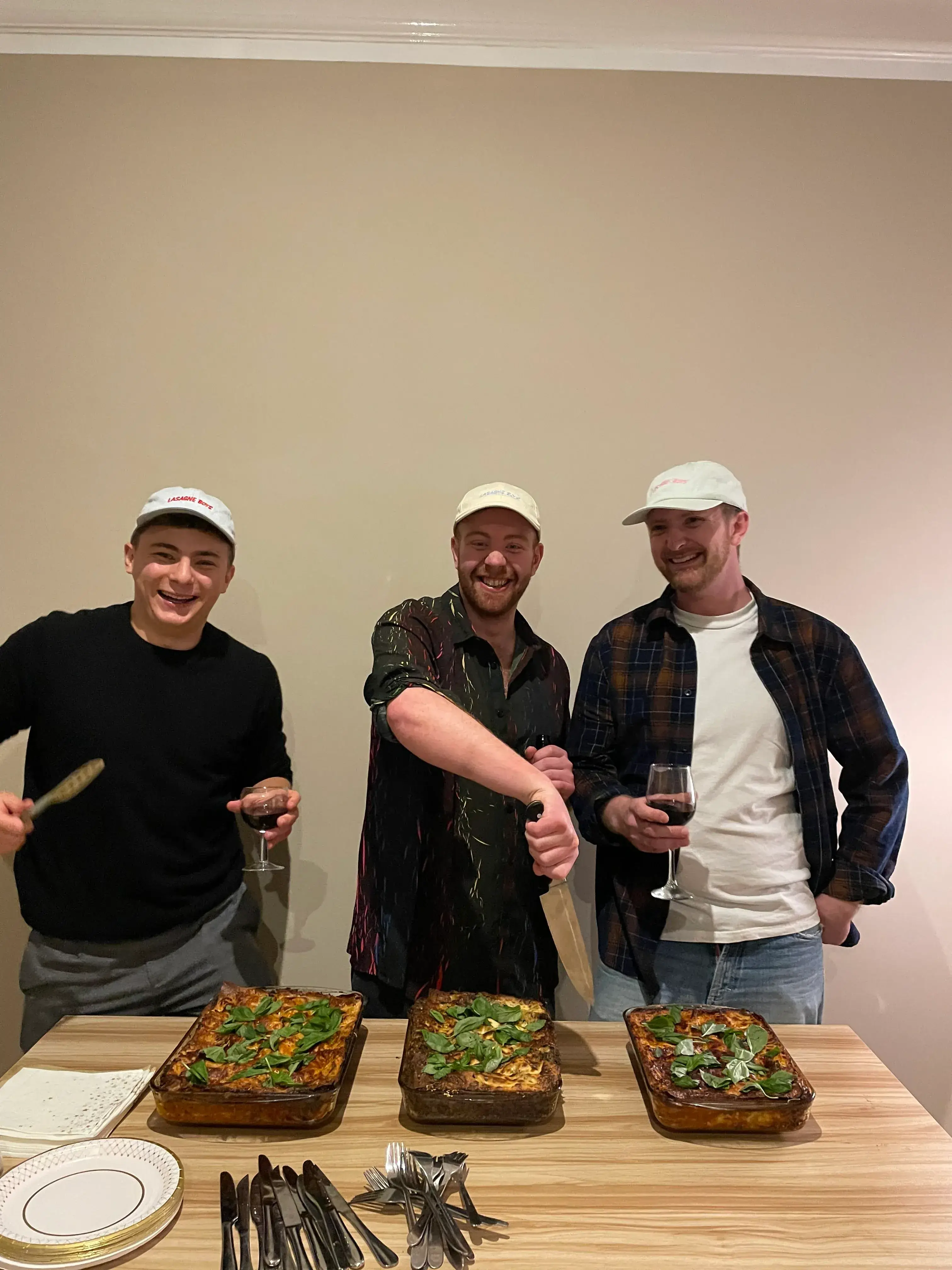 Three happy boys digging into some yummy lasagne